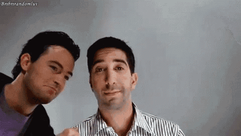 two men are standing next to each other and looking at the camera .