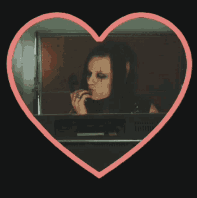 a woman talking on a phone in a pink heart shaped frame