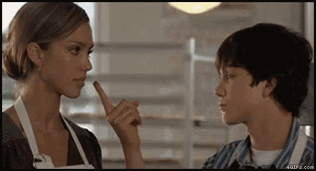 a man and a woman are looking at each other and the woman is pointing at the man .