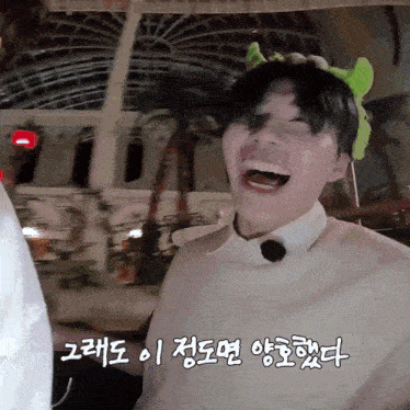 a man wearing a headband with green ears laughs