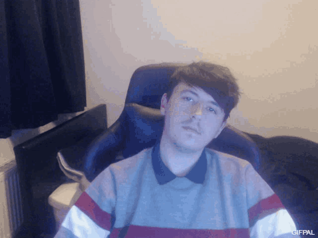 a man is sitting in a chair with a gifpal watermark on the bottom right