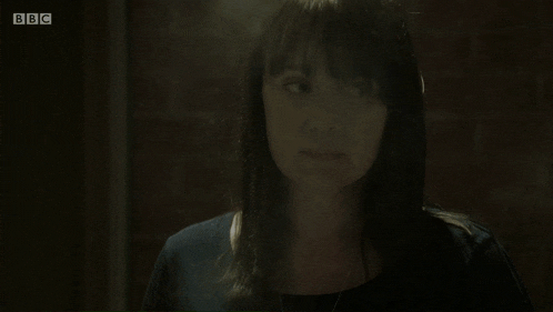 a woman in a dark room with the bbc logo on the bottom