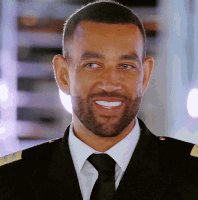 a man with a beard wearing a suit and tie smiles for the camera