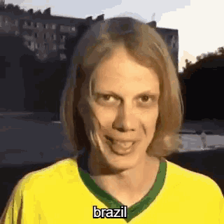 a man wearing a yellow shirt with the word brazil on it is making a funny face .