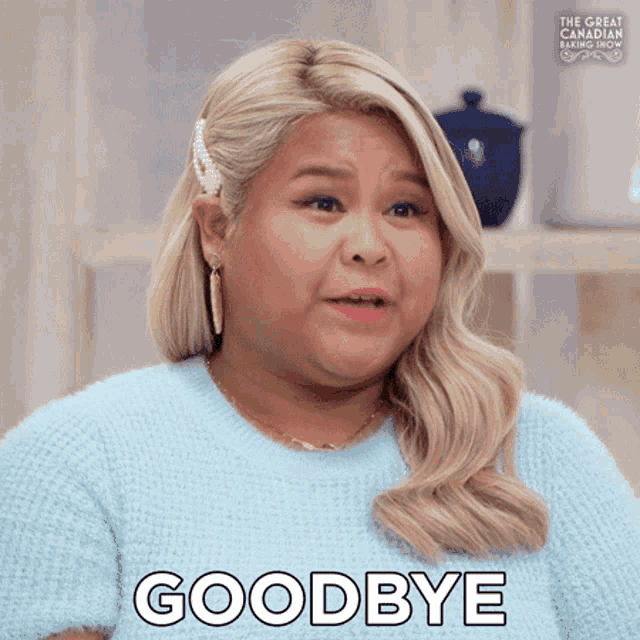 a woman says goodbye in a blue sweater