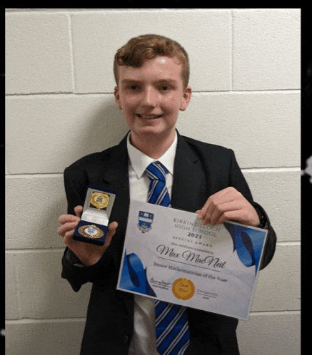 a young man in a suit and tie is holding a certificate and medal