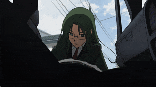 a girl with green hair and glasses is sitting in a dark room