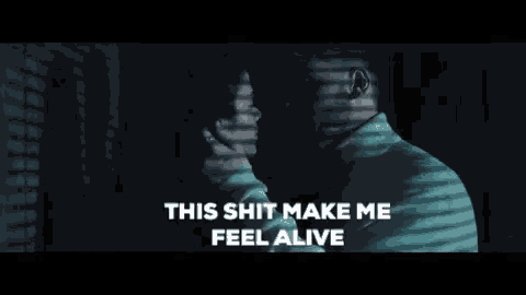 a man and woman are kissing in a dark room with the words this shit make me feel alive