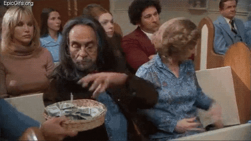 a man is holding a basket of money in front of a group of people .