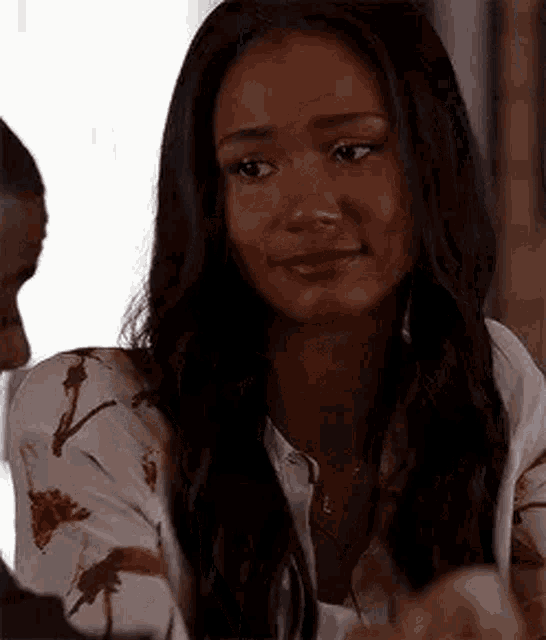 a woman is sitting at a table with a man and looking at him .