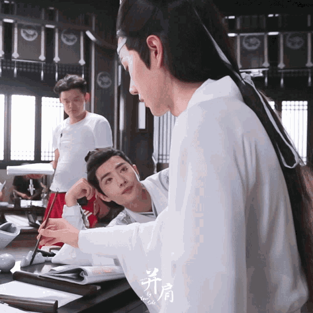 a man in a white shirt is holding a brush while another man looks on