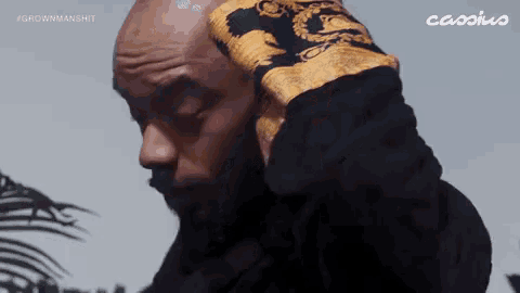 a man wearing a black and gold shirt with the word cassius on the bottom