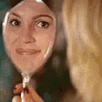 a woman is looking at her reflection in a mirror