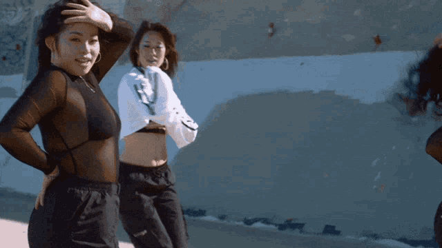two women are dancing in front of a building