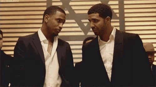 two men in suits are standing next to each other in a room .