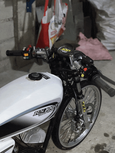 a white motorcycle with the word ks100 on the tank