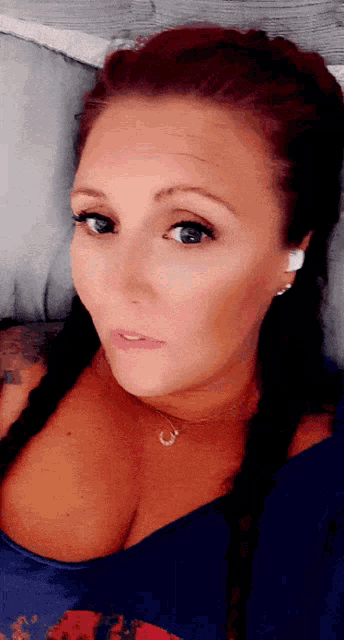 a woman with red hair is wearing a blue top