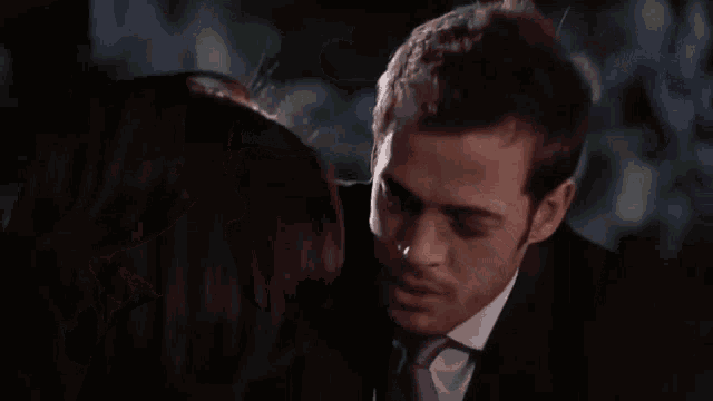 a man is touching a woman 's neck in a close up of a movie .