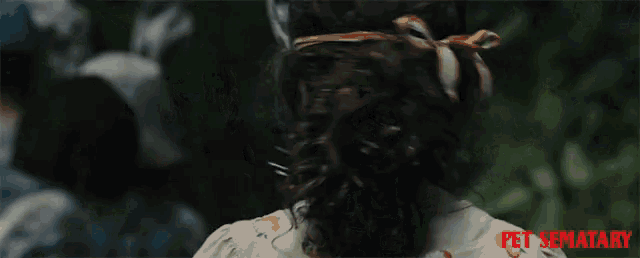 a girl wearing a cat mask with pet sematary written on the bottom right