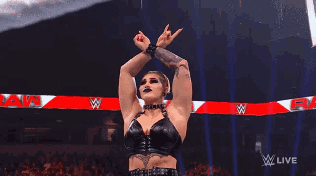 a female wrestler is making a rock sign with her hands