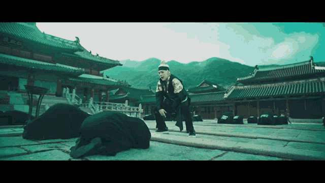a man is kneeling down in front of a temple