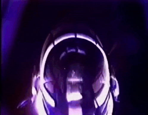 a person is wearing headphones in a dark room with a purple light coming out of it .