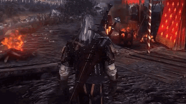 a man with a sword and shield is standing in front of a burning tent in a video game .