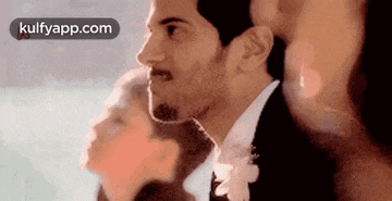 a man in a suit and tie is standing next to a woman in a wedding dress .
