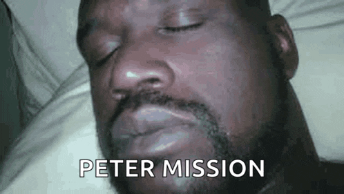 a man with a beard is laying in bed with his eyes closed and the words peter mission written on his face .
