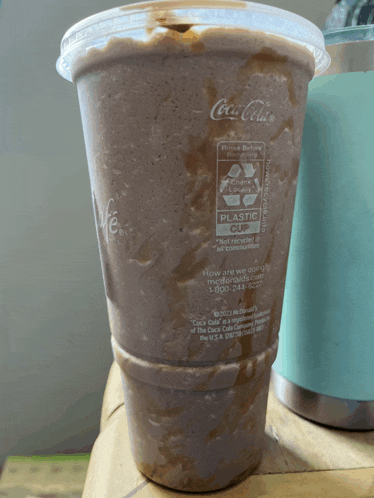 a coca-cola cup with a plastic cup on it