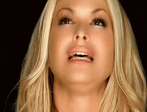 a woman with blonde hair is looking up at the camera