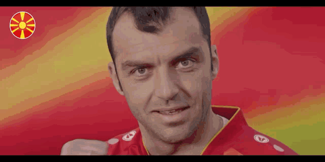 a man wearing a red shirt with the letter a on the front