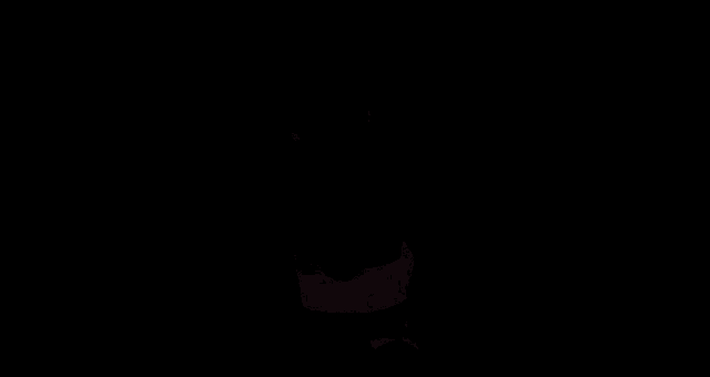 a woman in a black sports bra and gray leggings is sitting on the floor .