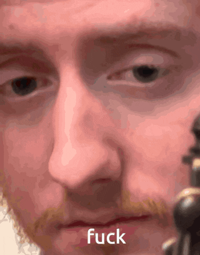 a close up of a man 's face with the word fuck visible
