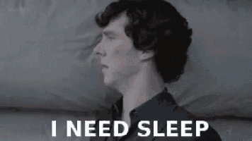 a man is laying on a bed with the words `` i need sleep '' written on the screen .