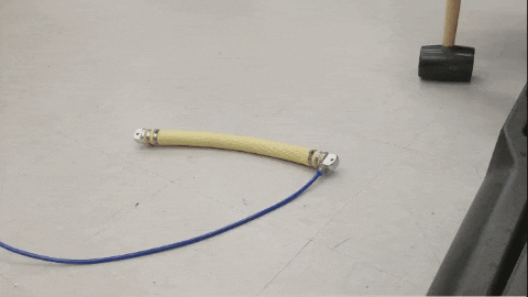 a person is holding a hammer over a yellow object on the floor