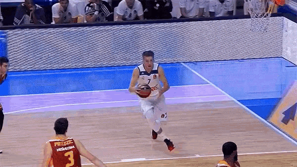 a basketball player wearing a jersey with the number 3 on it dribbles the ball
