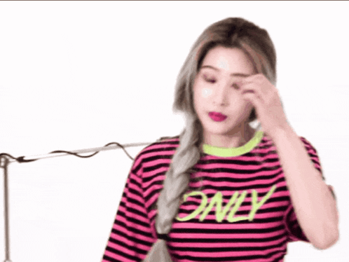 a woman wearing a pink and black striped shirt that says only on it