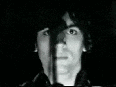 a black and white photo of a man 's face with a microphone in his mouth .