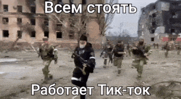 a group of soldiers are running down a dirt road with russian writing