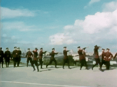 a group of men in military uniforms are walking down a street