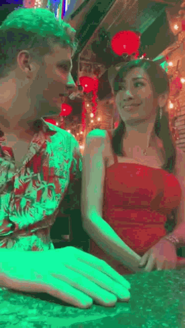 a man and a woman are looking at each other while sitting at a bar