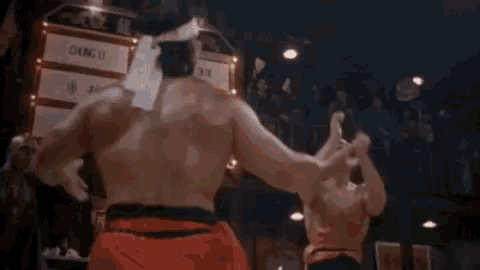 two men are fighting in a boxing ring with a yellow flame coming out of the ring .