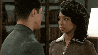 a man and woman are looking at each other and the woman is wearing a leopard print beret