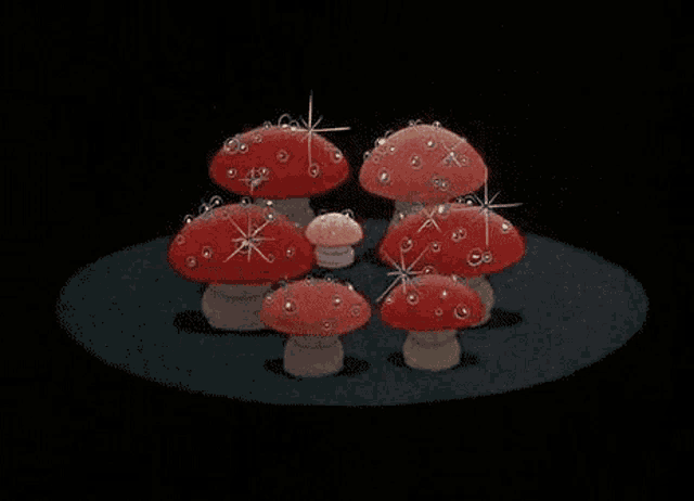 a group of red mushrooms are standing next to each other on a black background .