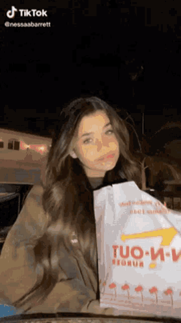 a girl is holding a bag that says tuo-m-e