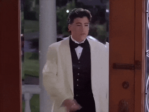 a young man in a tuxedo is standing in a doorway
