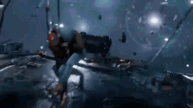 a man is sitting on the ground next to a car that has crashed into a wall .