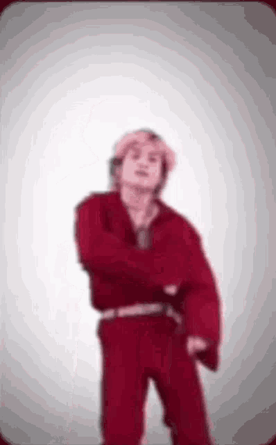 a man in a red shirt and red pants is dancing .