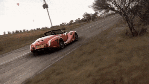 a red sports car is driving down a road with a license plate that says ' aaa '